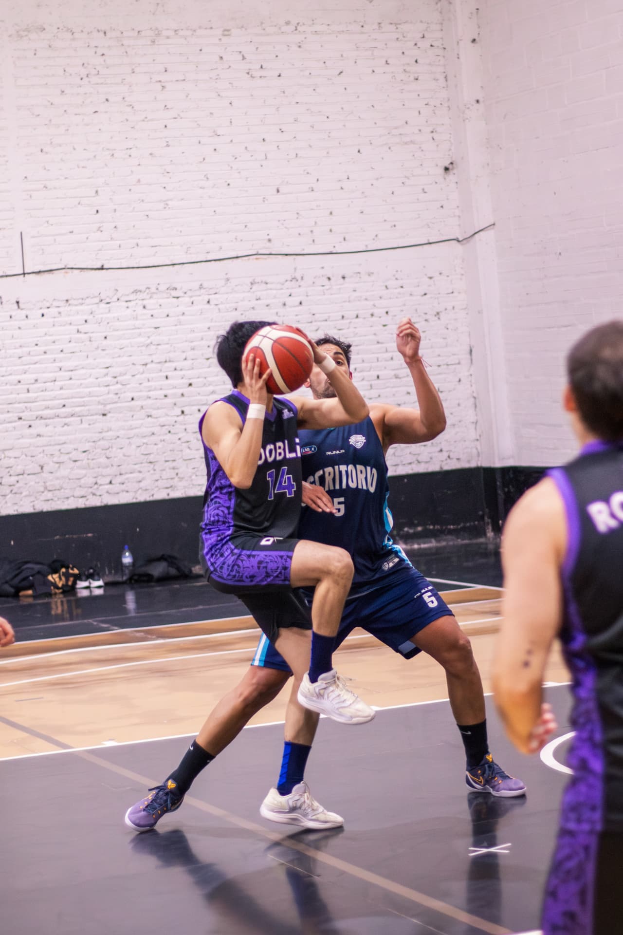 Jugador de básquet protegiendo la pelota frente a la marca rival
