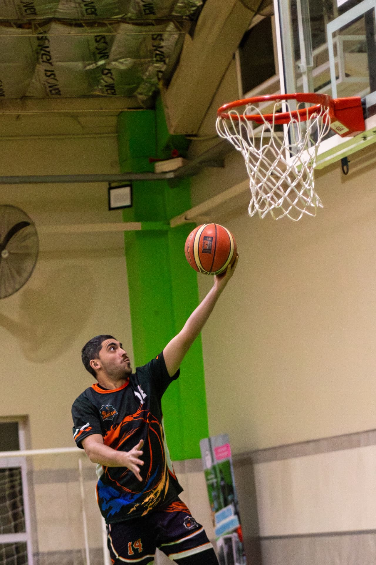 Jugador de básquet en suspensión apoyando la pelota en el aro