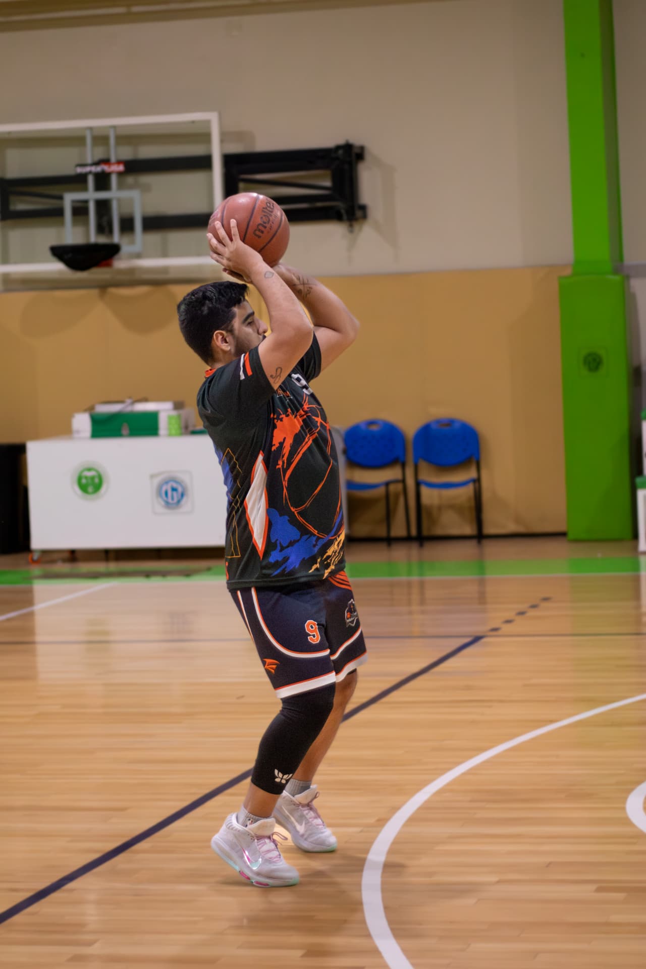 Jugador de básquet ejecutando un lanzamiento de perfil en la cancha