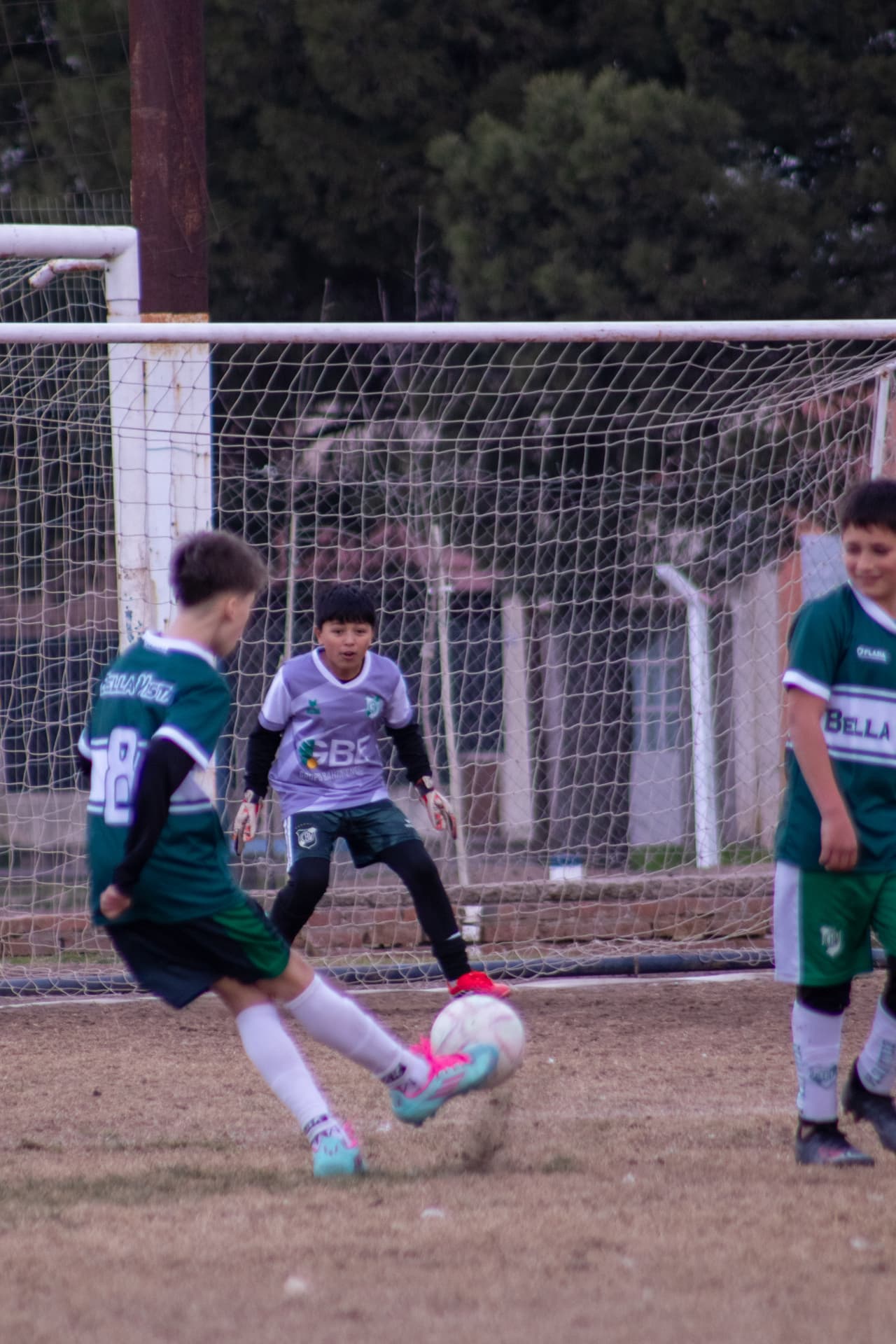 Niño definiendo frente al arquero en un partido de fútbol infantil